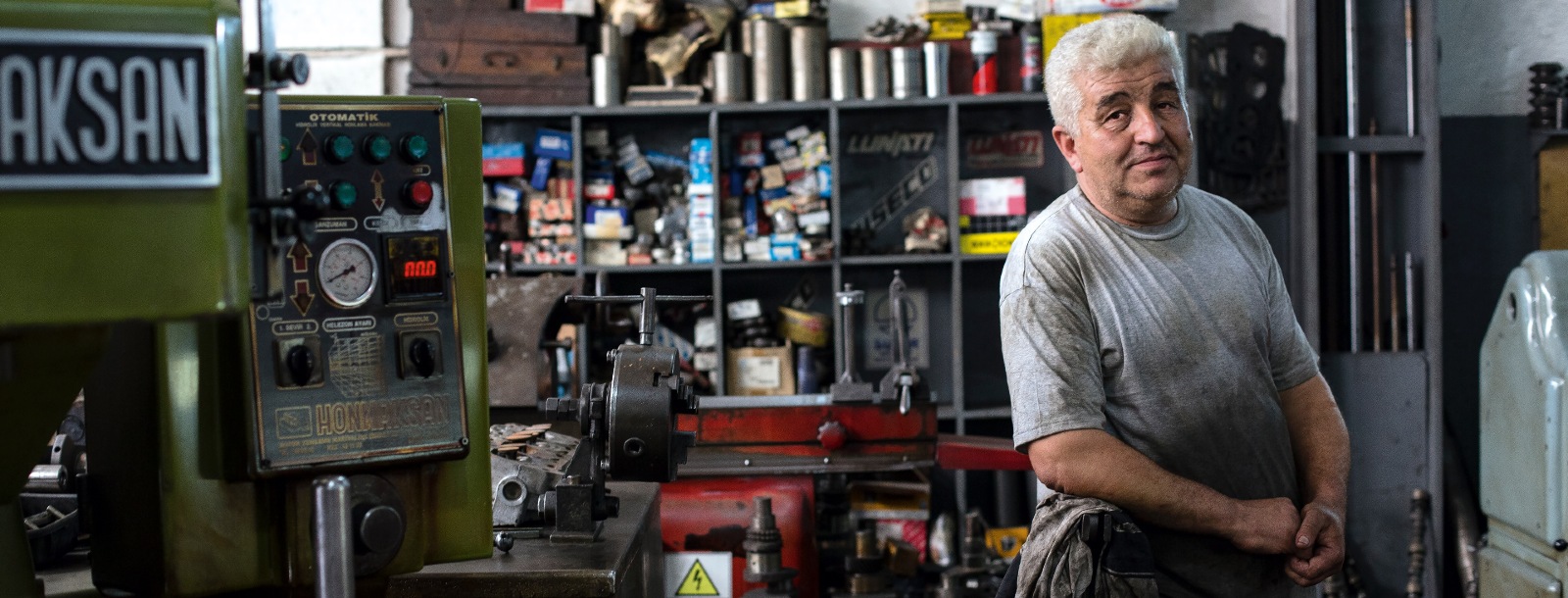 man sitting in an engine shop surrounded by machinery