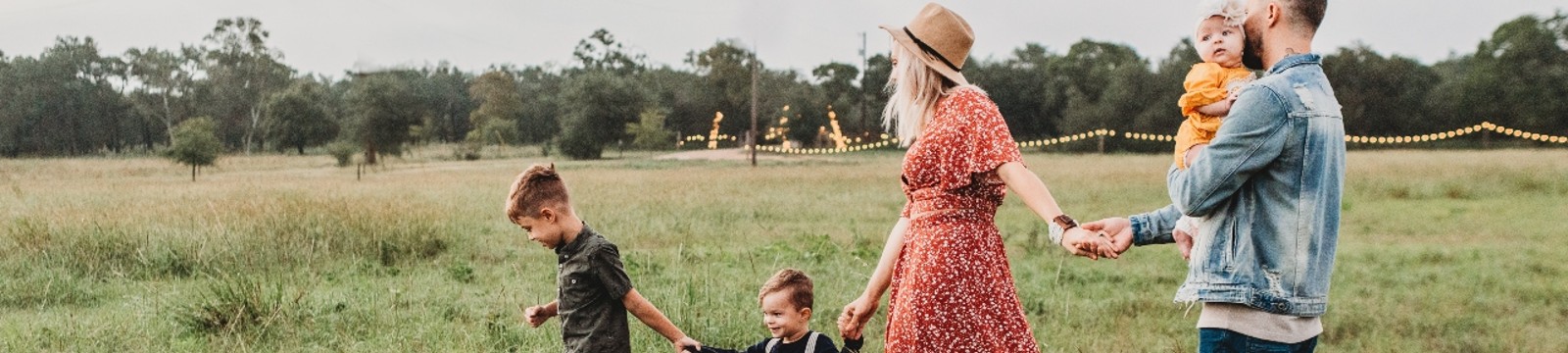 Family walking through field holding hands